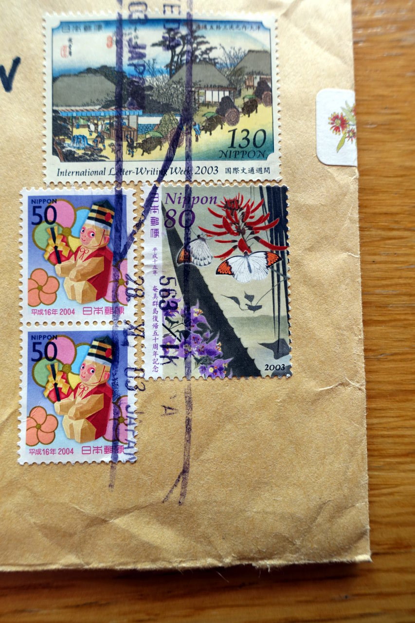 Part of an envelope with four different Japanese stamps.