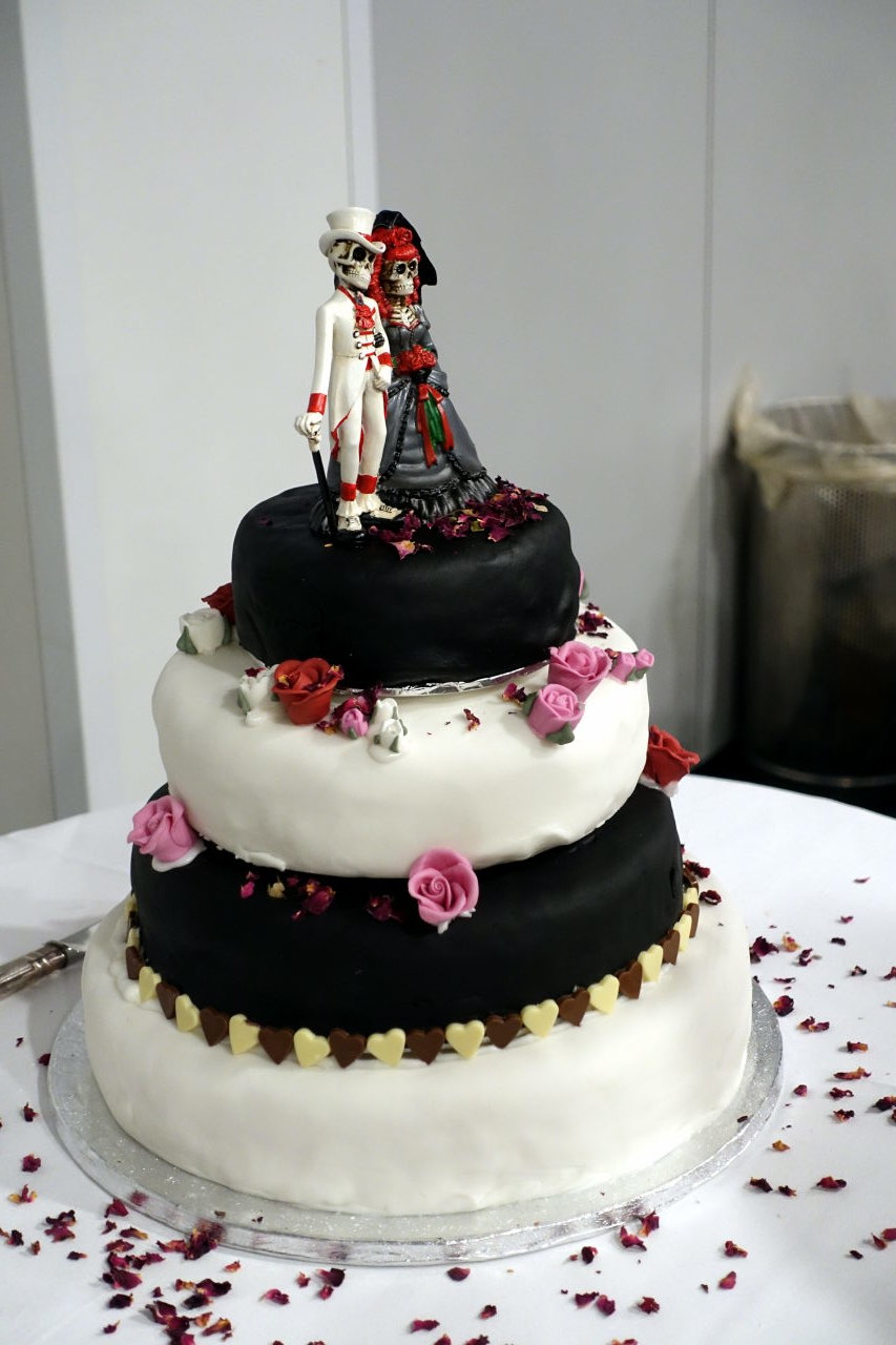 Four levels wedding cake with a skeletons' couple on top.