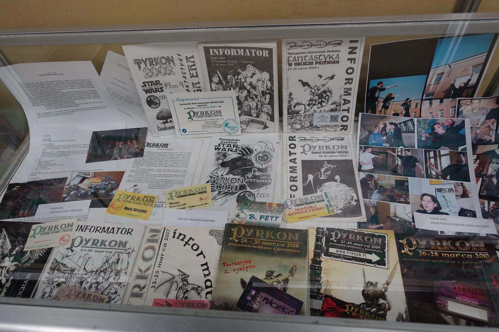 Picture showing some programme books, badges, pictures, and other memorabilia from the past conventions.