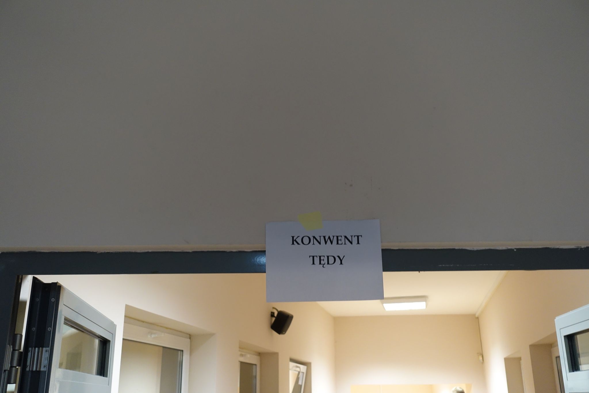 A piece of paper is glued on top of the door. It has a 'Konwent tędy' inscription.